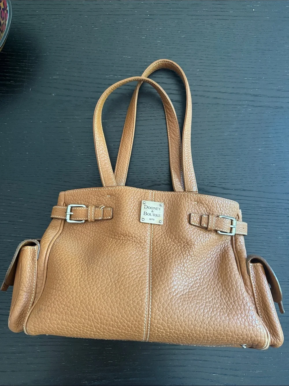 Dooney & Bourke tan pebbled leather side pockets belted satchel bag.